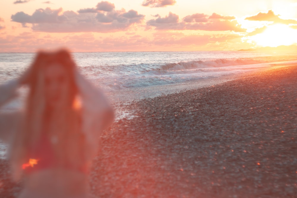 Una foto borrosa de una mujer parada en una playa