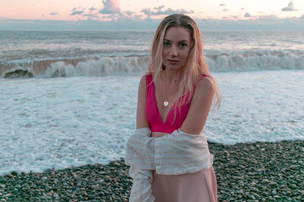 a woman standing on a beach next to the ocean