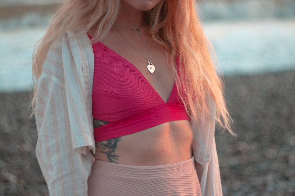 a woman wearing a pink bikini top and a white cardigan