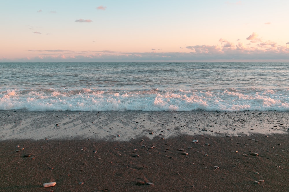 a beach with a wave coming in to shore