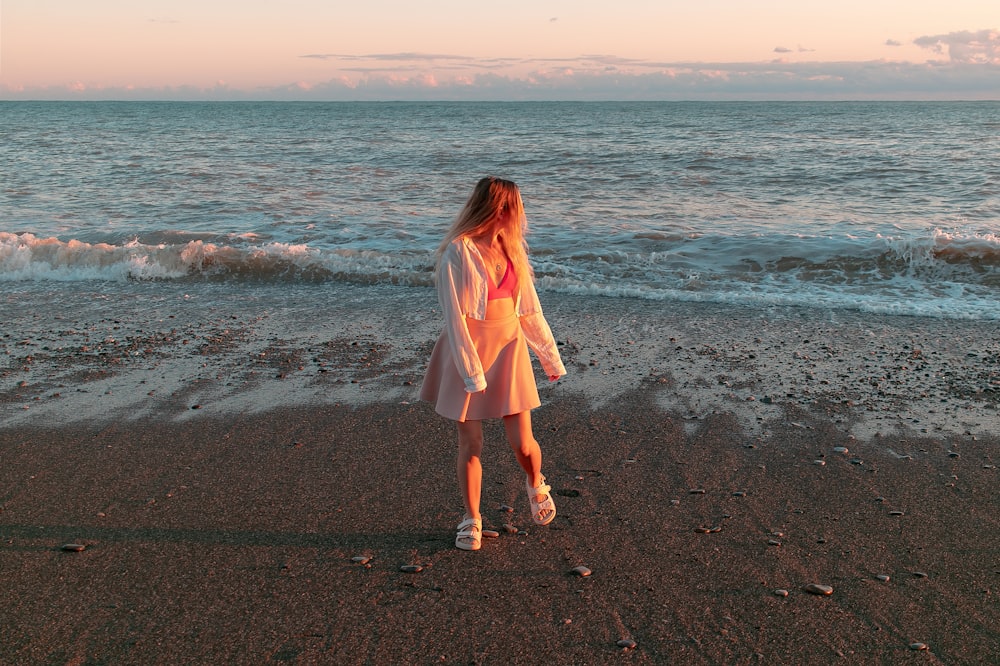 uma mulher em pé em uma praia ao lado do oceano