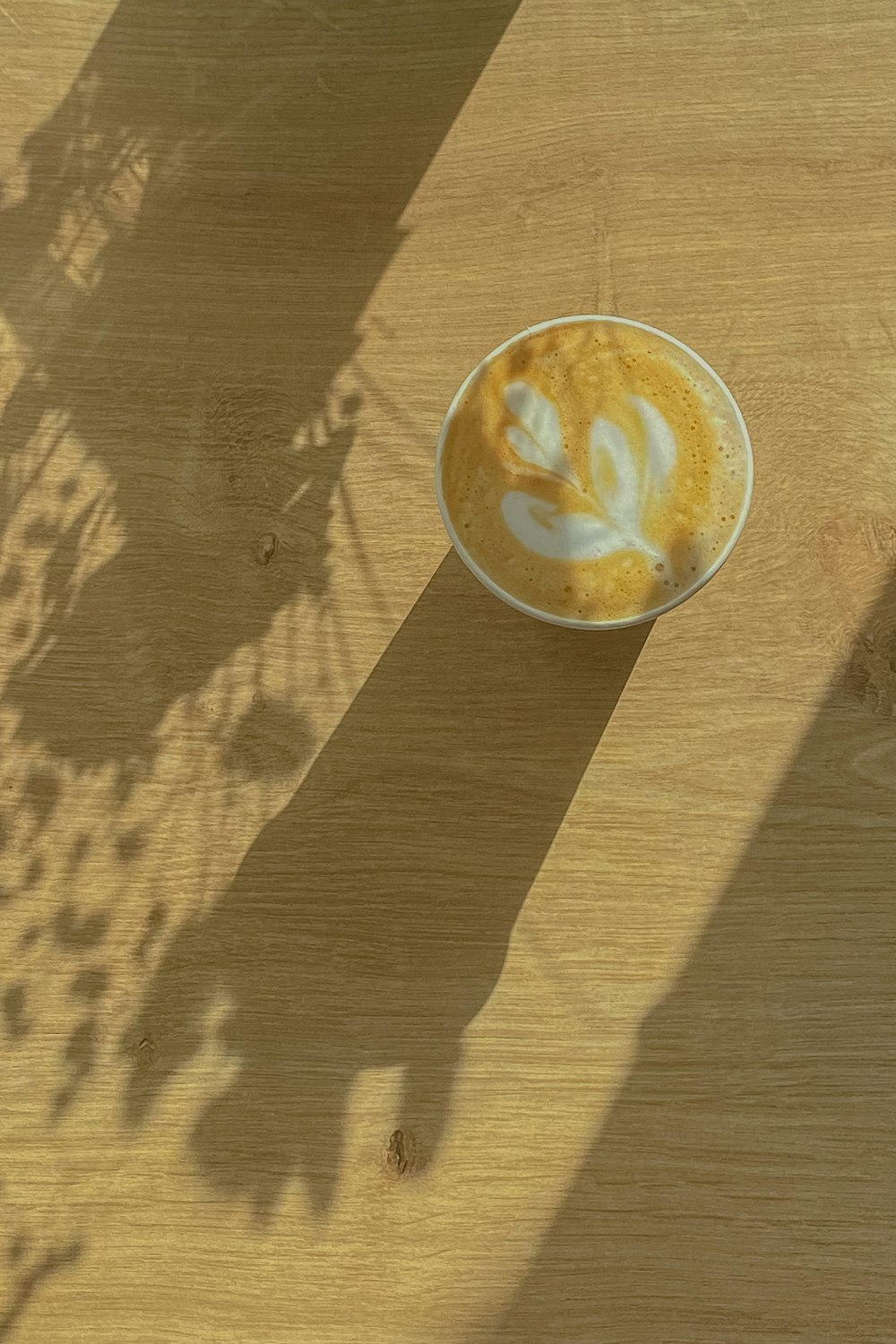 a cup of cappuccino on a wooden table