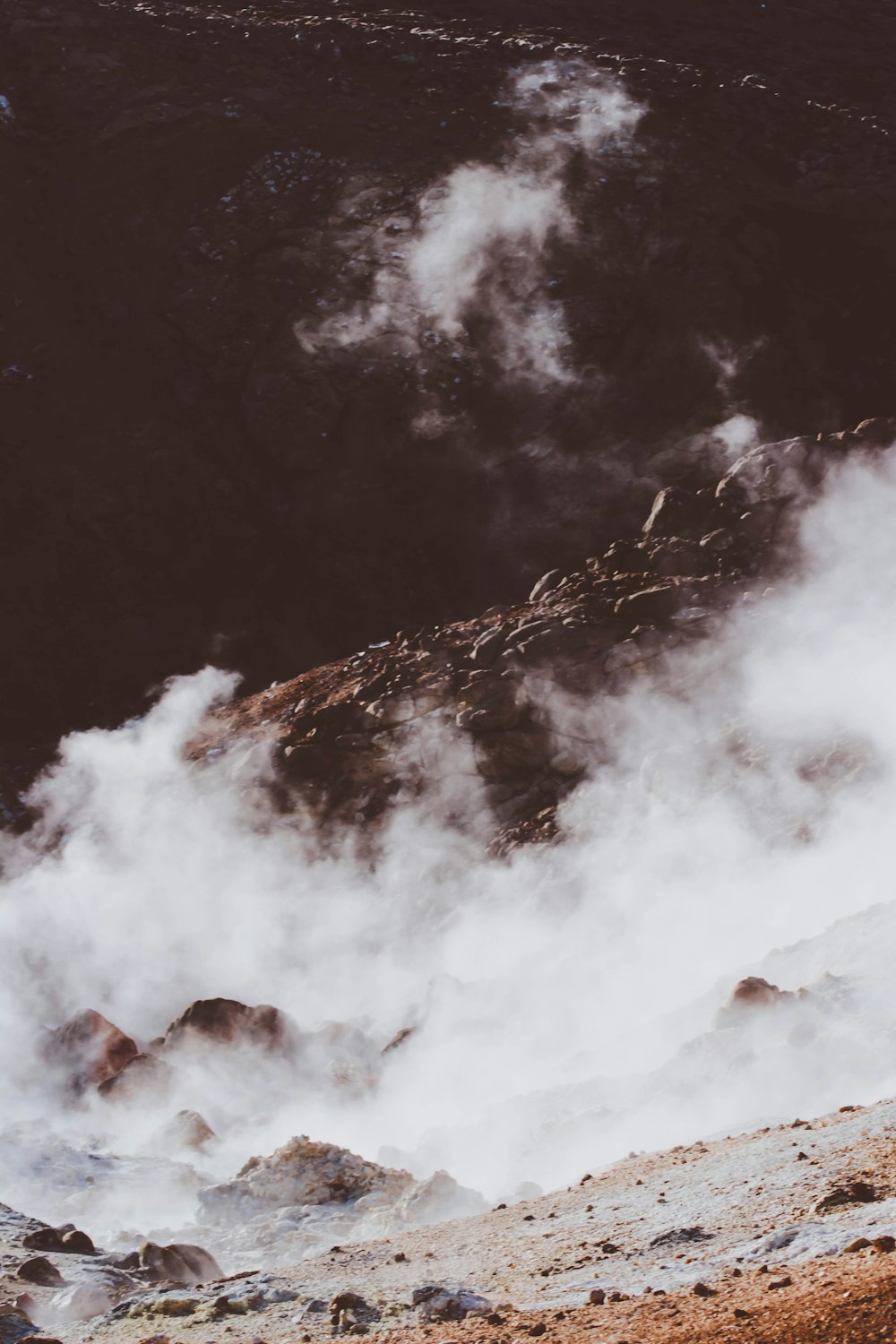 a man standing on top of a mountain next to a fire hydrant