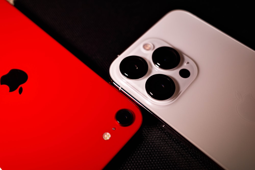 두 개의 빨간색과 흰색 아이폰이 나란히 앉아