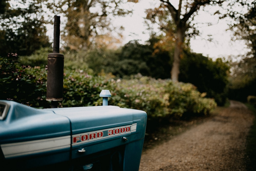 a blue truck parked on top of a dirt road