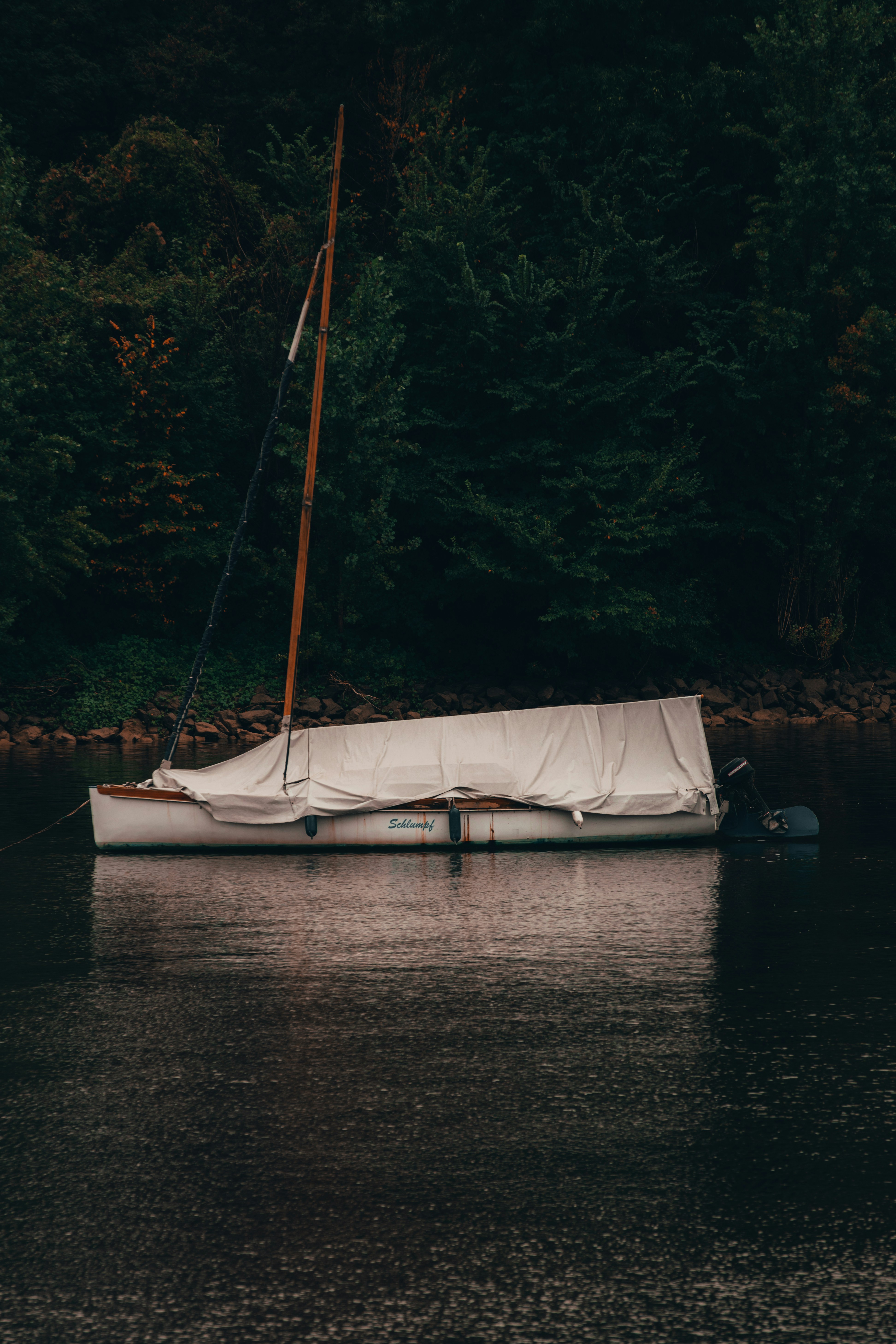a small sailboat floating on top of a body of water