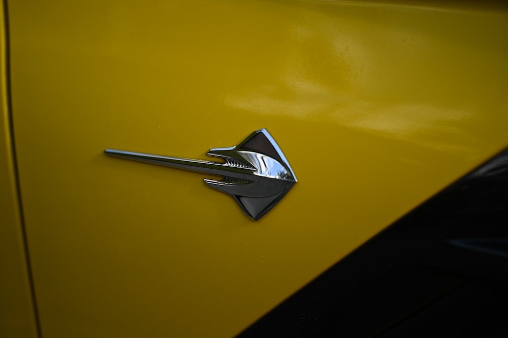 a close up of the emblem on a yellow car