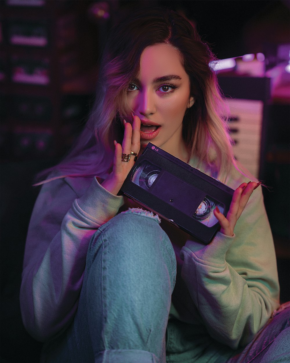 a woman sitting on the floor holding a tape recorder