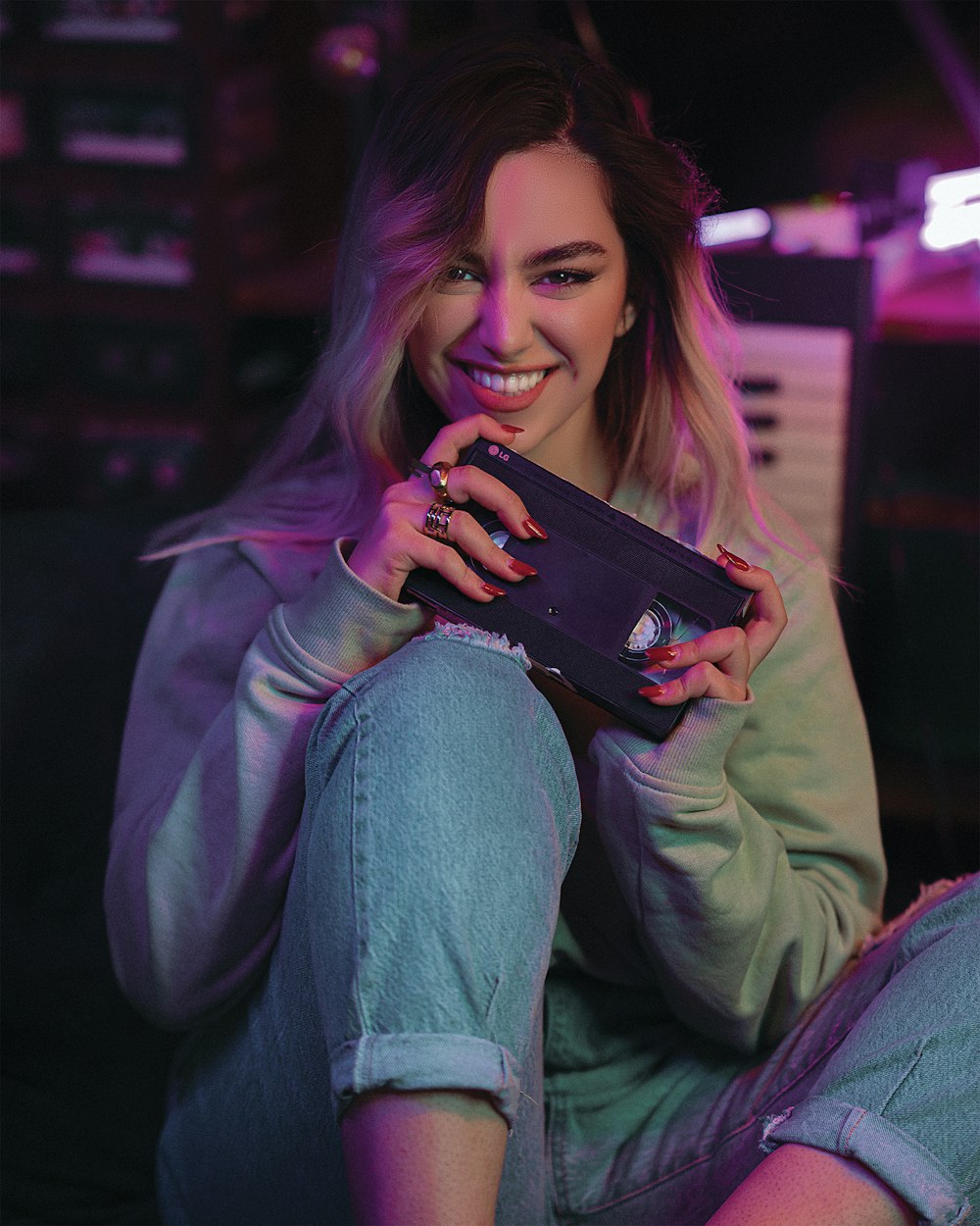 a woman sitting on the floor holding a cell phone