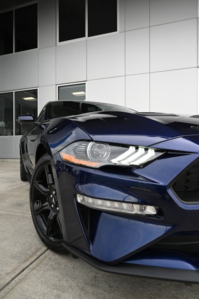 a blue sports car parked in front of a building