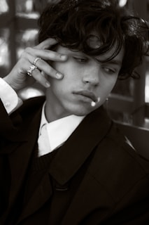 An editorial-style shot of a person looking thoughtfully at their reflection, dressed in a simple yet elegant outfit.