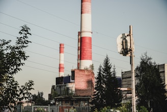 a red and white smokestack sitting next to a tall building
