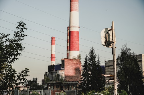 a red and white smokestack sitting next to a tall building