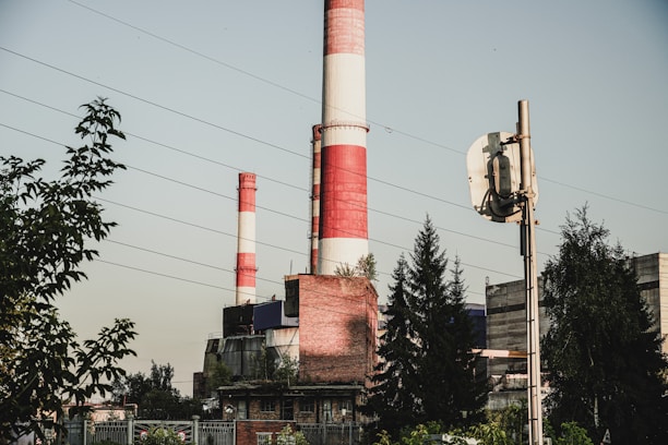a red and white smokestack sitting next to a tall building