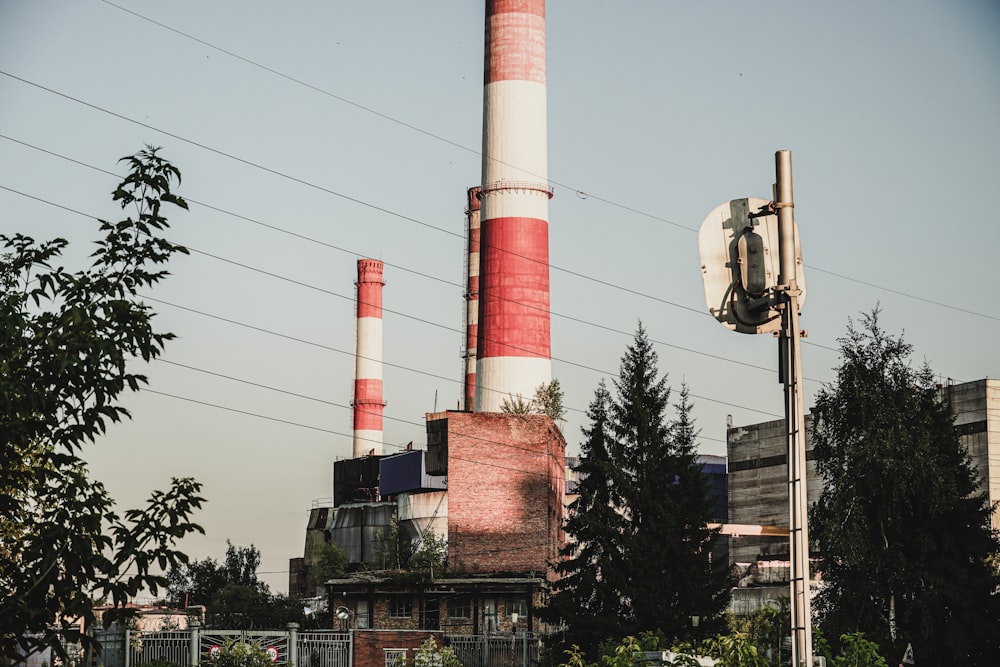 a red and white smokestack sitting next to a tall building