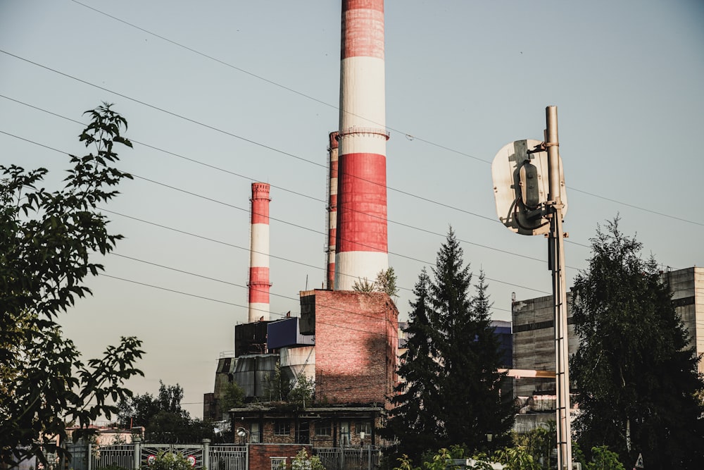 une cheminée rouge et blanche assise à côté d’un grand immeuble