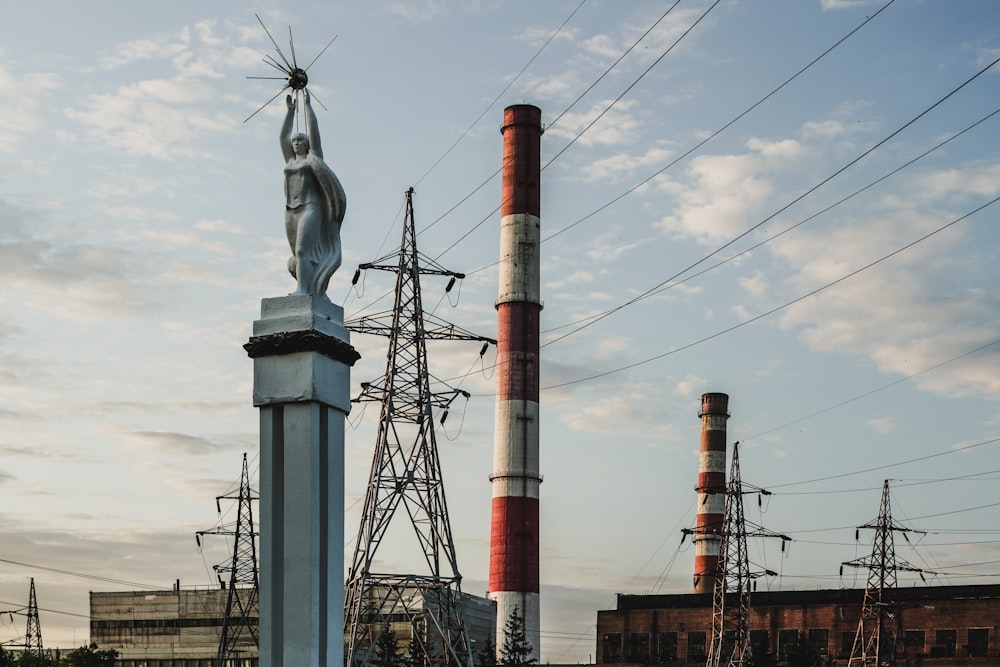 a statue on top of a pillar in front of power lines