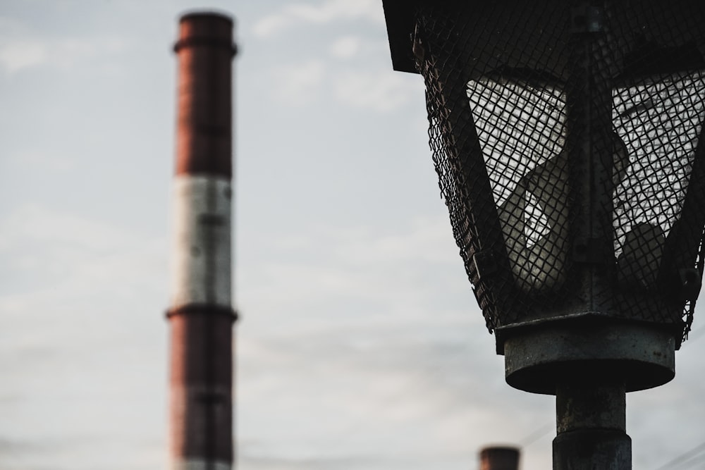 a street light next to a chimney on a cloudy day