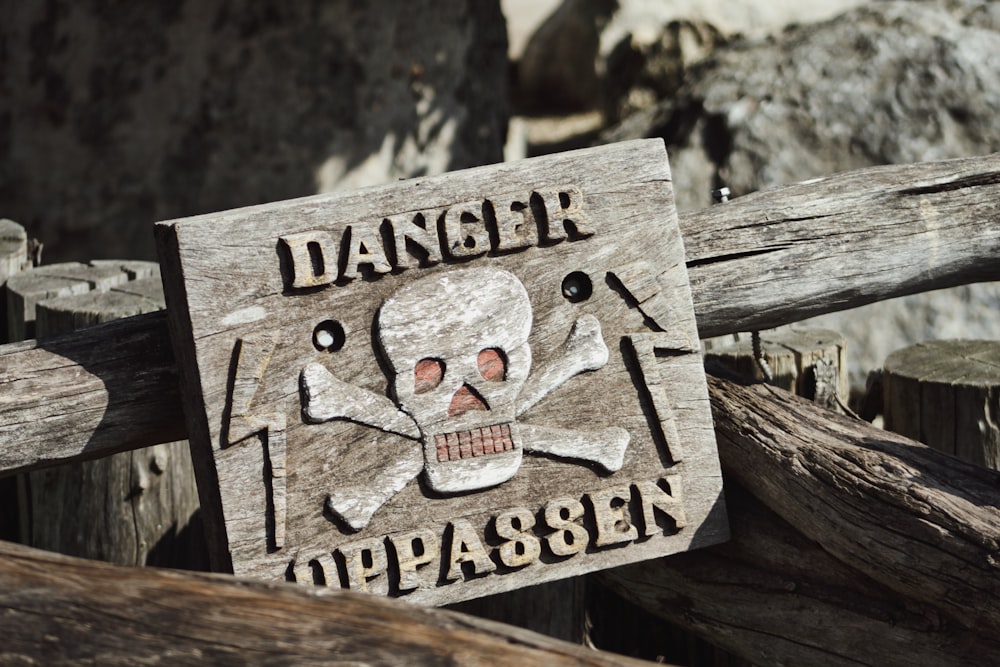 a wooden sign with a skull and bones on it