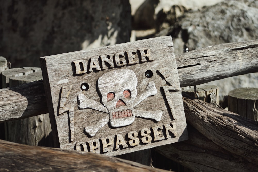 ein Holzschild mit einem Totenkopf und Knochen darauf