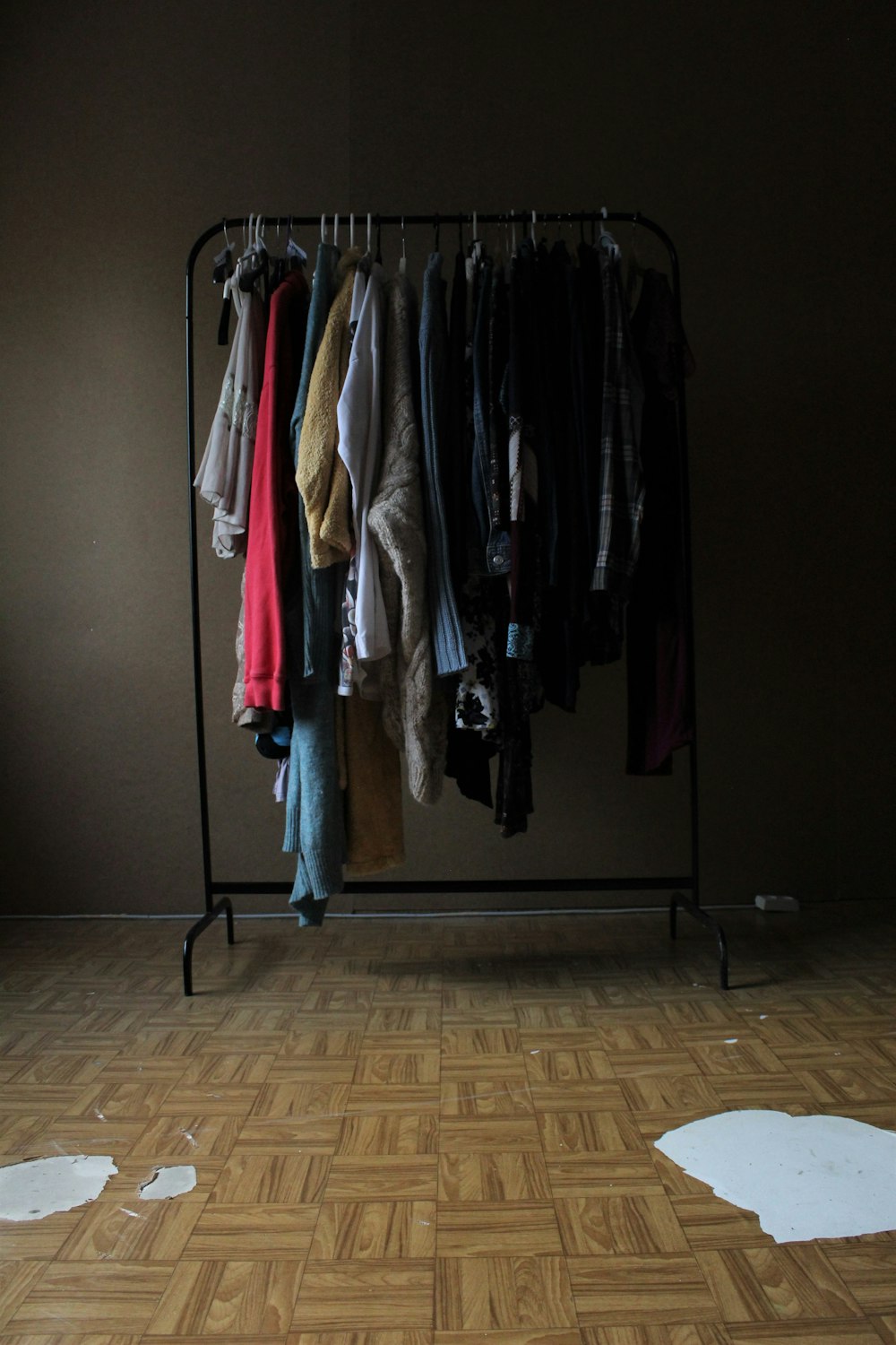 a rack of clothes on a wooden floor