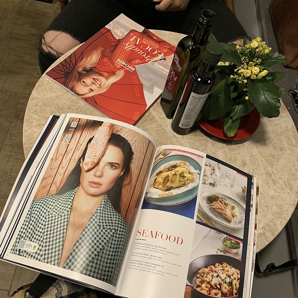 a person sitting at a table with a magazine open