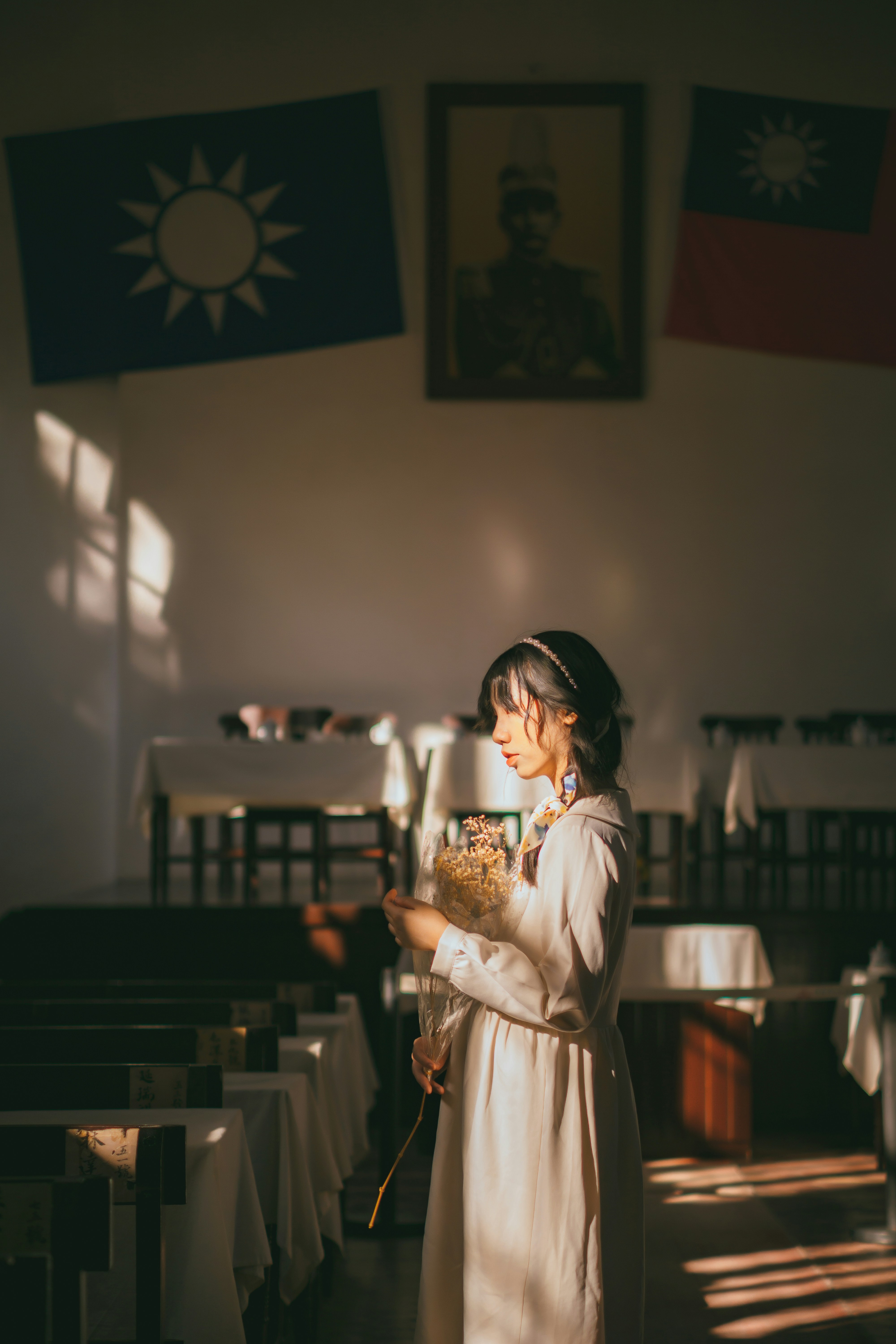 Seorang wanita berdiri di sebuah gereja sambil memegang buket bunga