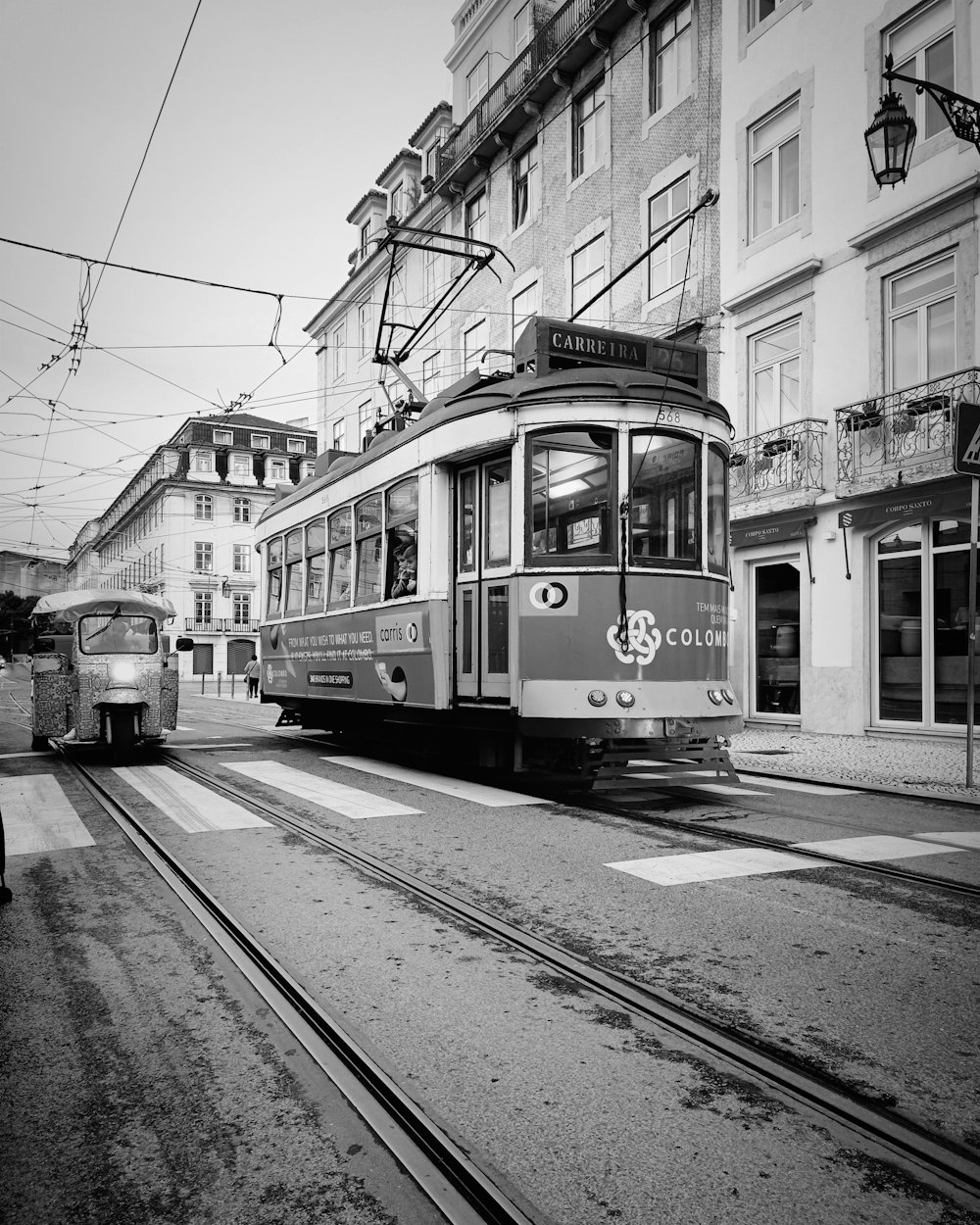 a black and white photo of a trolley on a street
