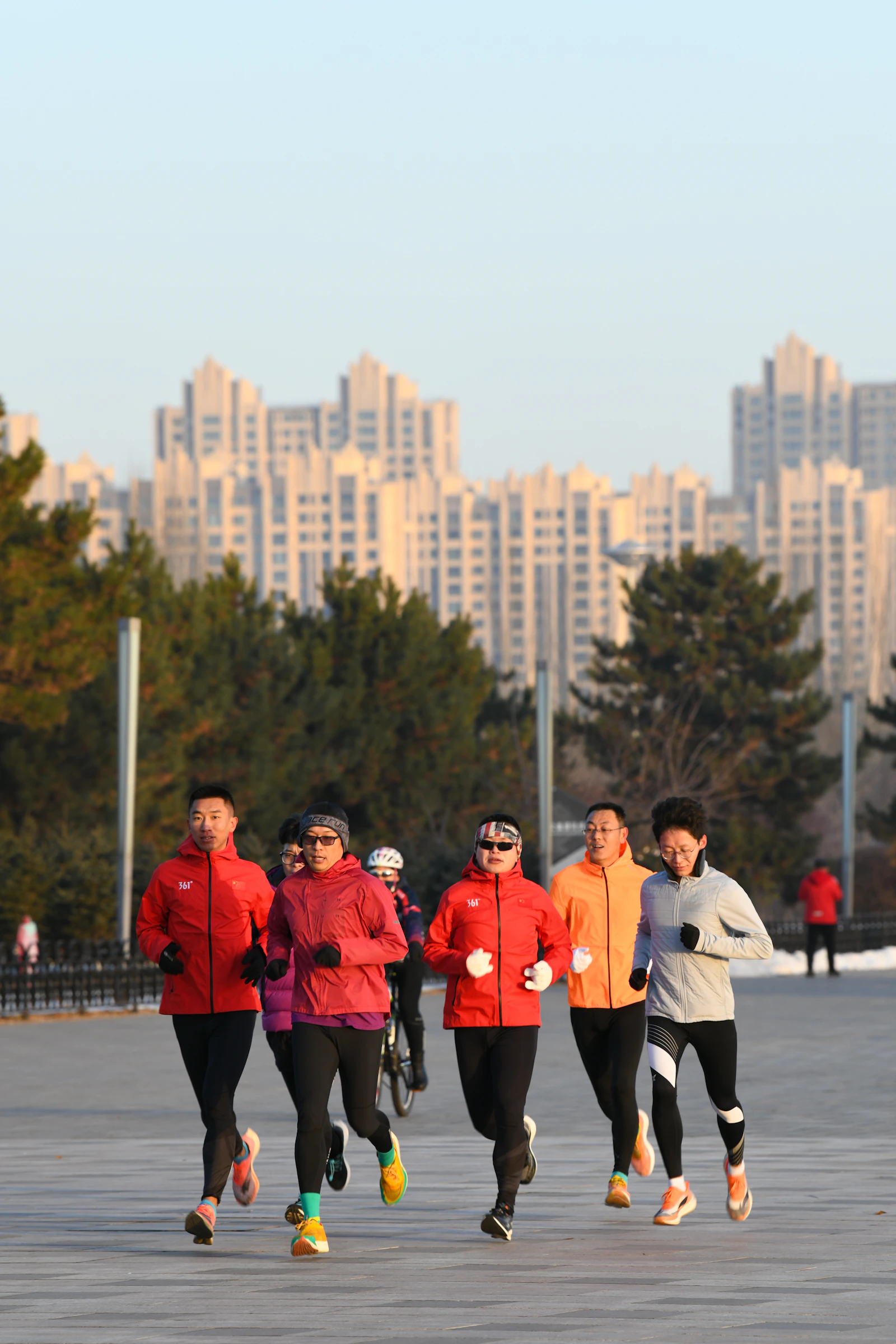 A group of people running together in a park; illustrative photography