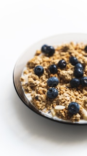 a white plate topped with granola and blueberries