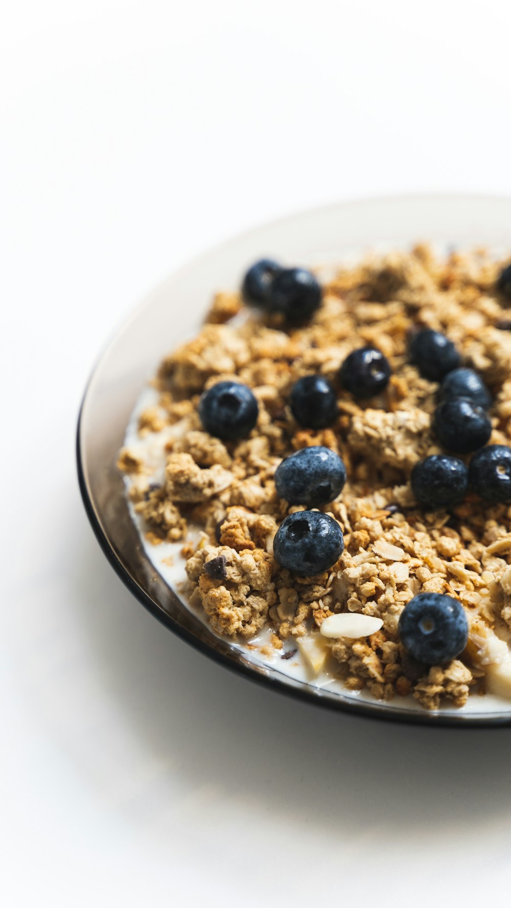 a white plate topped with granola and blueberries