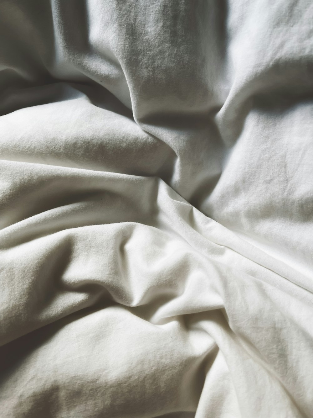 a close up of a bed with white sheets