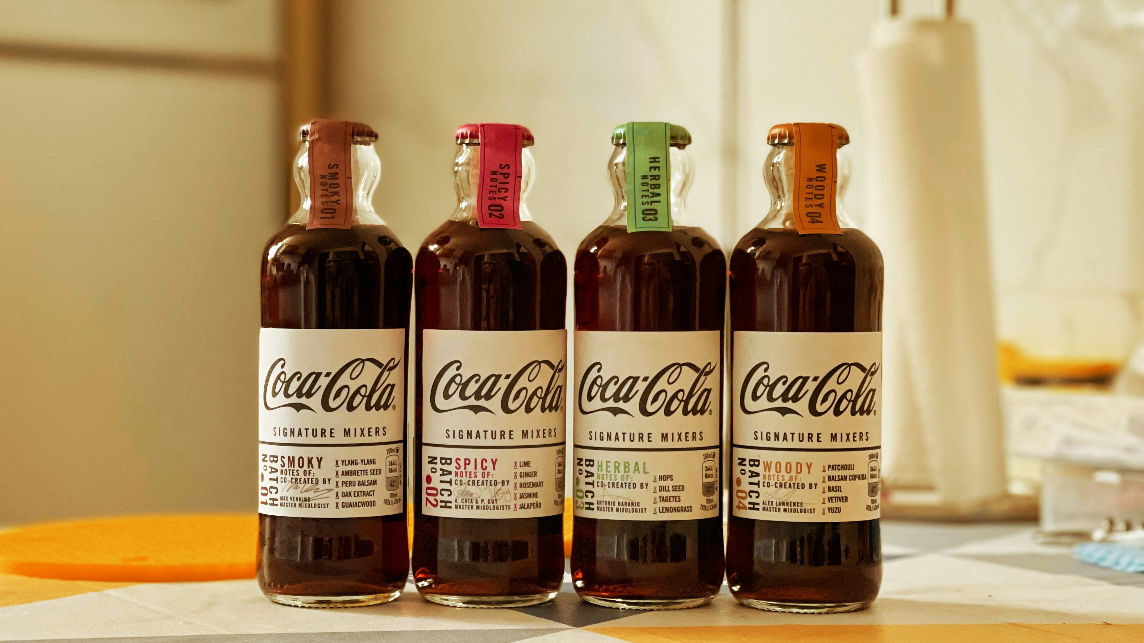 three bottles of coca cola sitting on top of a counter