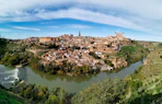 a river running through a small town surrounded by trees