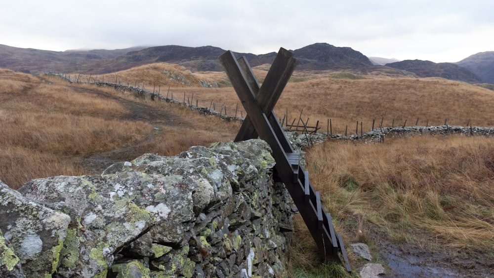 a stone wall with two wooden posts sticking out of it