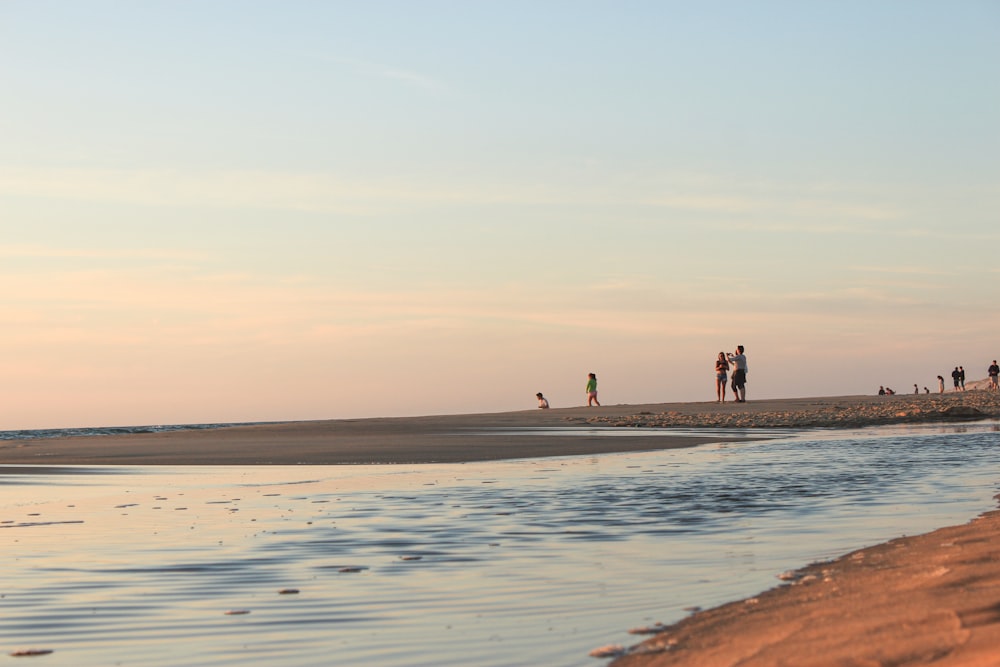 a group of people standing on top of a sandy beach