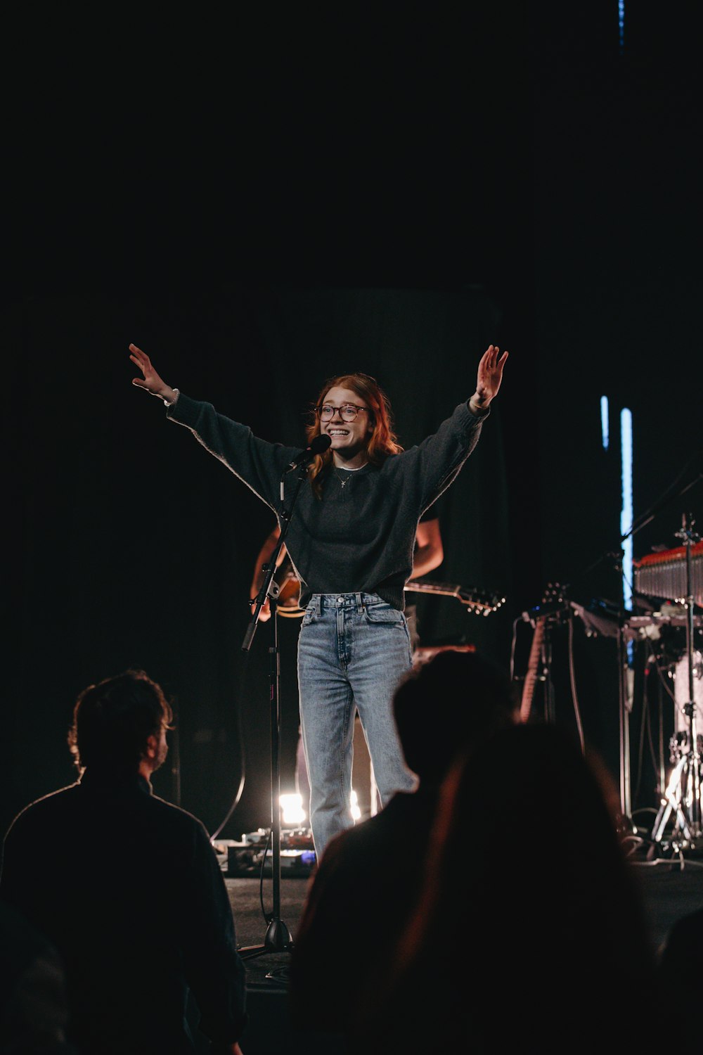 a man standing on a stage with his arms outstretched