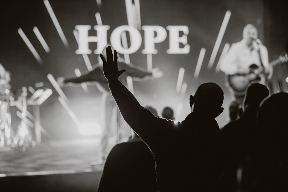 a man standing in front of a stage with his hands up