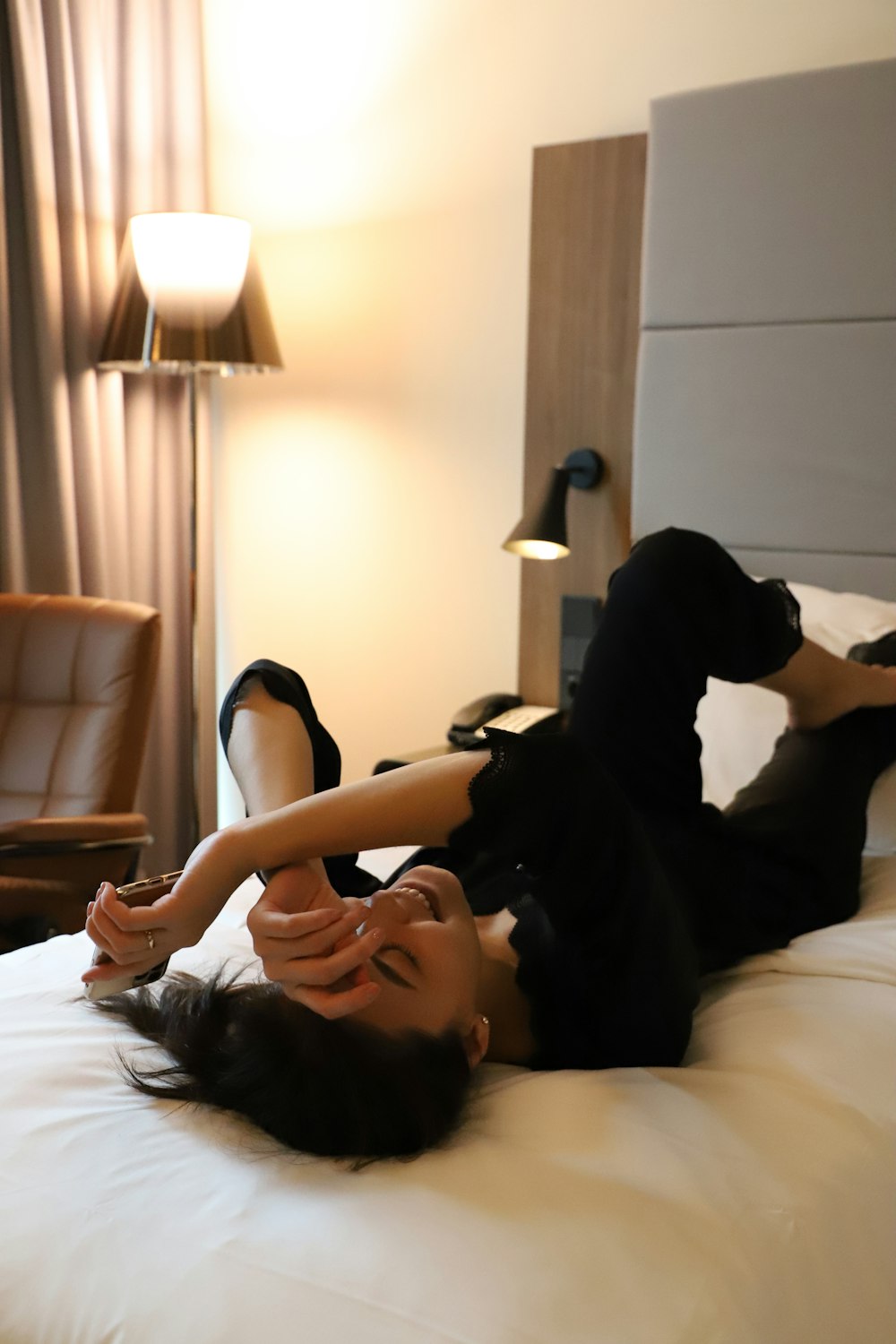 a woman laying on a bed in a hotel room