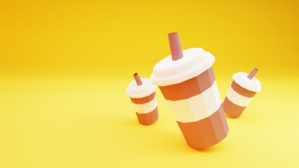 three paper cups with straws on a yellow background