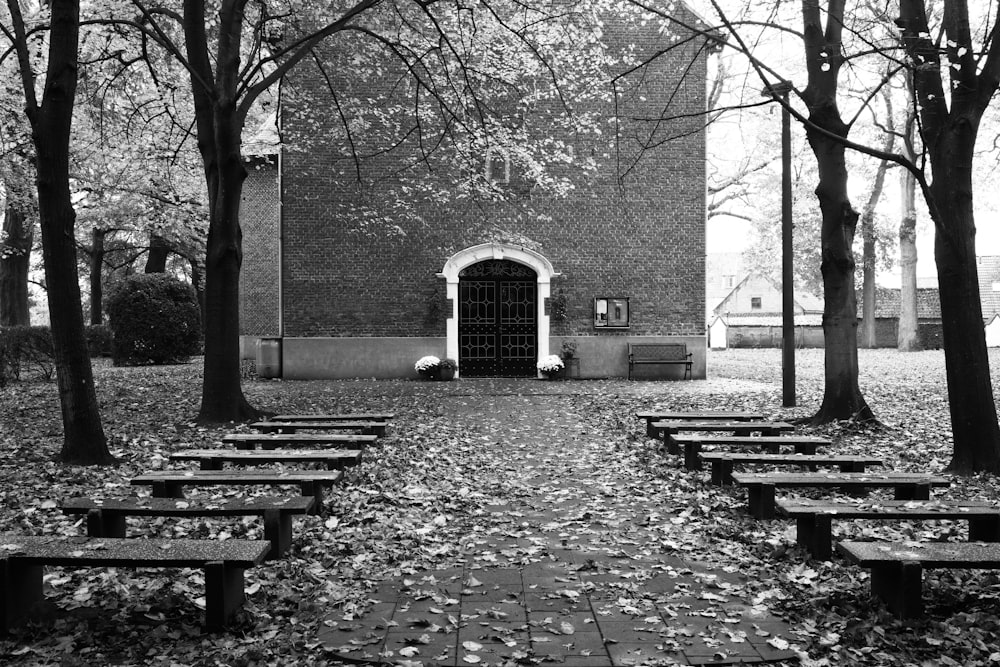 a black and white photo of a brick building surrounded by trees