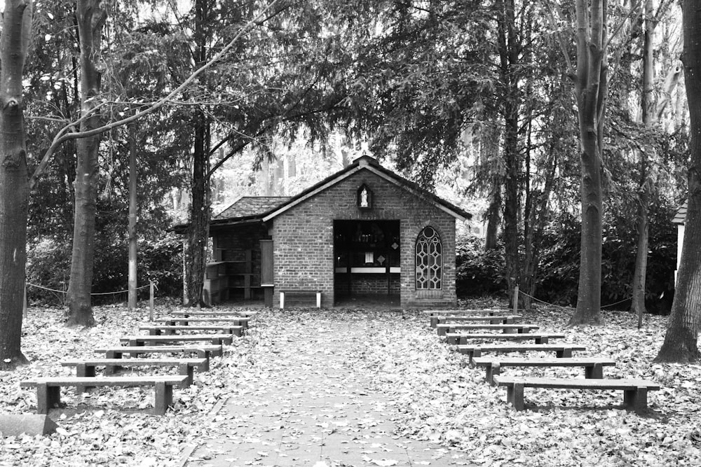a black and white photo of a small building in the woods