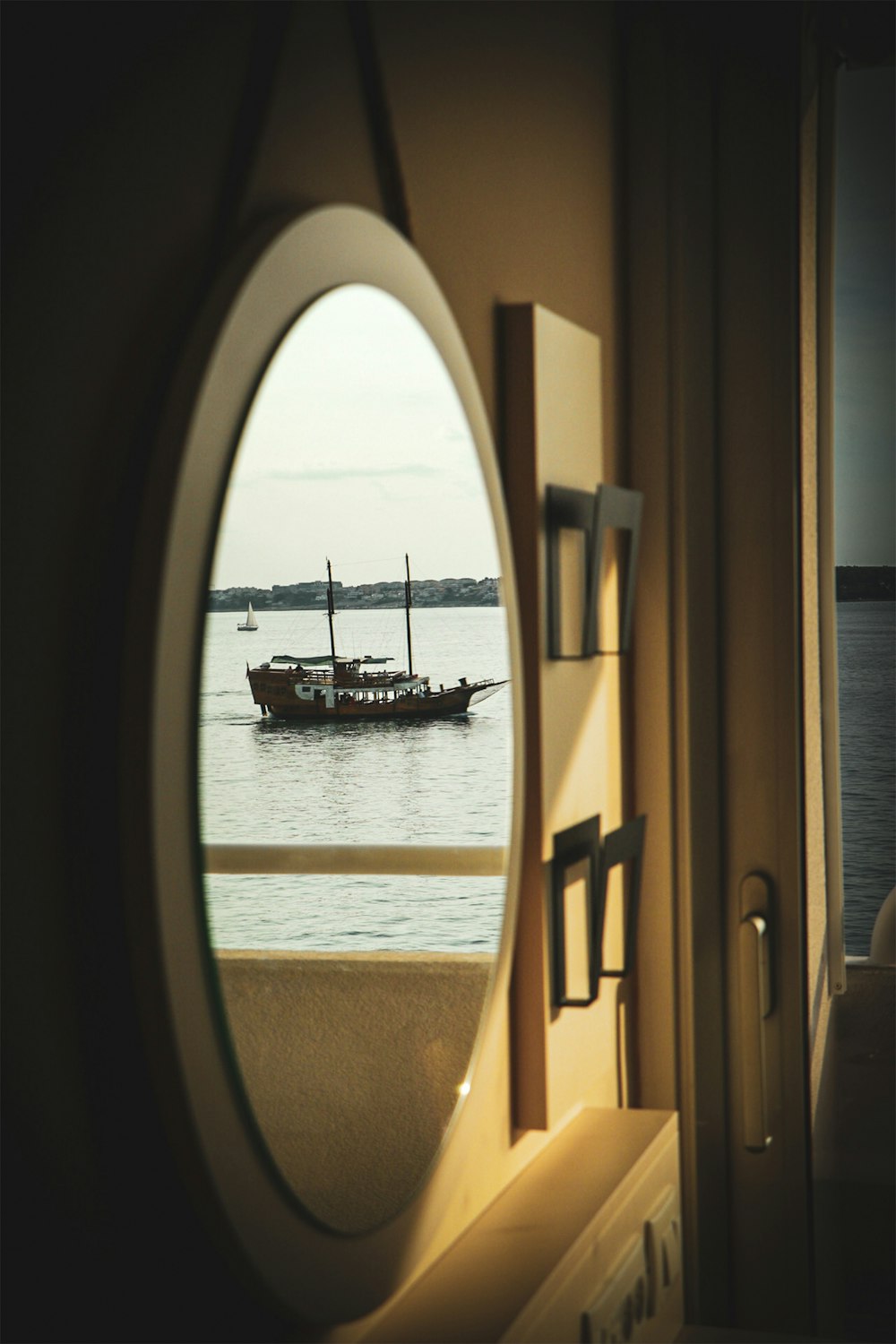 Un barco se ve a través de una ventana redonda