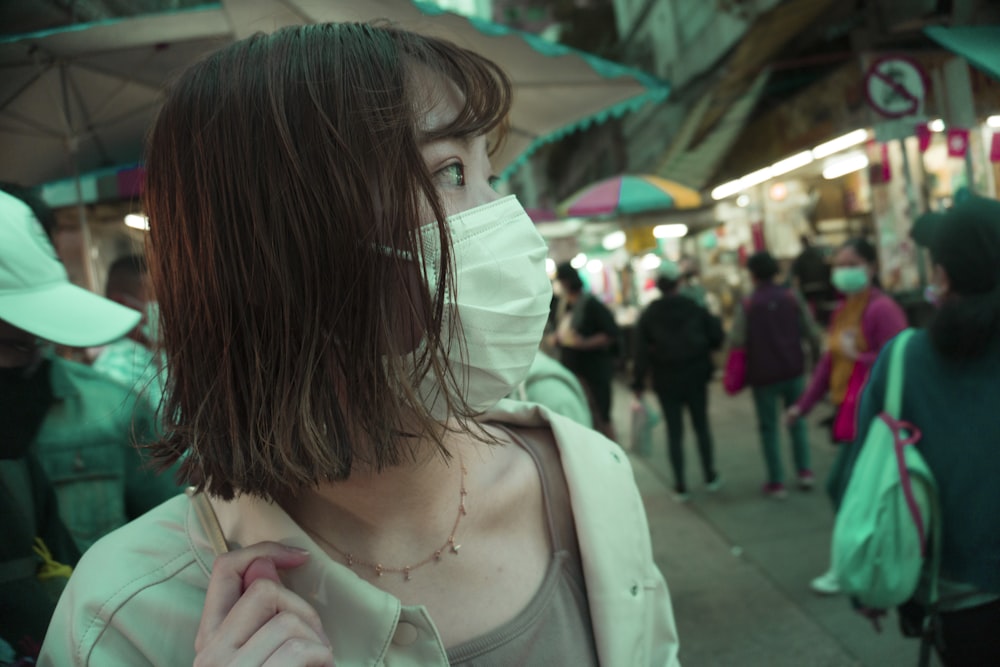 a woman wearing a face mask on a crowded street