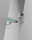 Two surveillance cameras are mounted on a stark, minimalist wall. The cameras have a teal body with orange accents and are connected by black cables. They are angled in different directions, suggesting active observation.