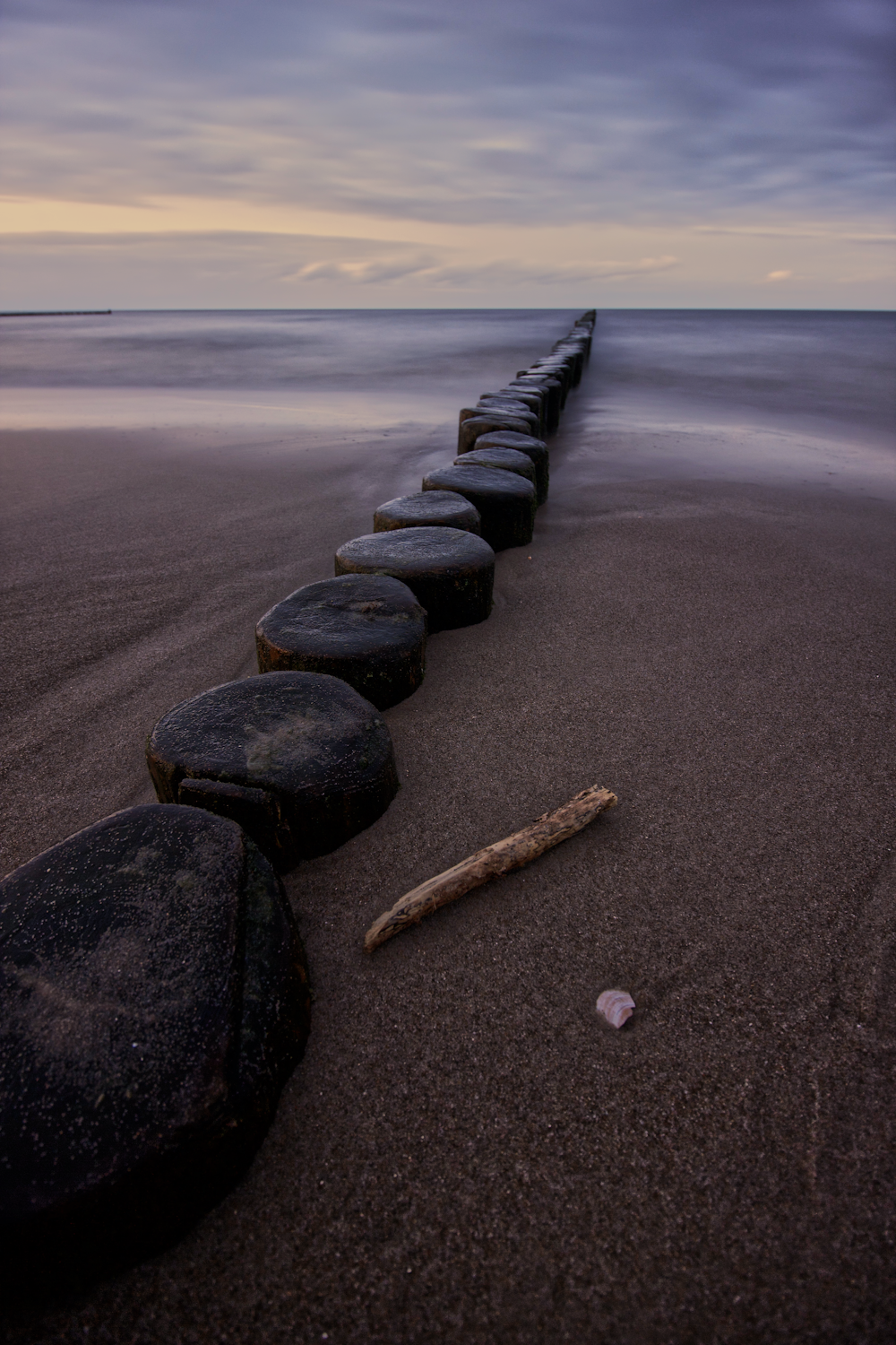 a long row of rocks sitting on top of a beach