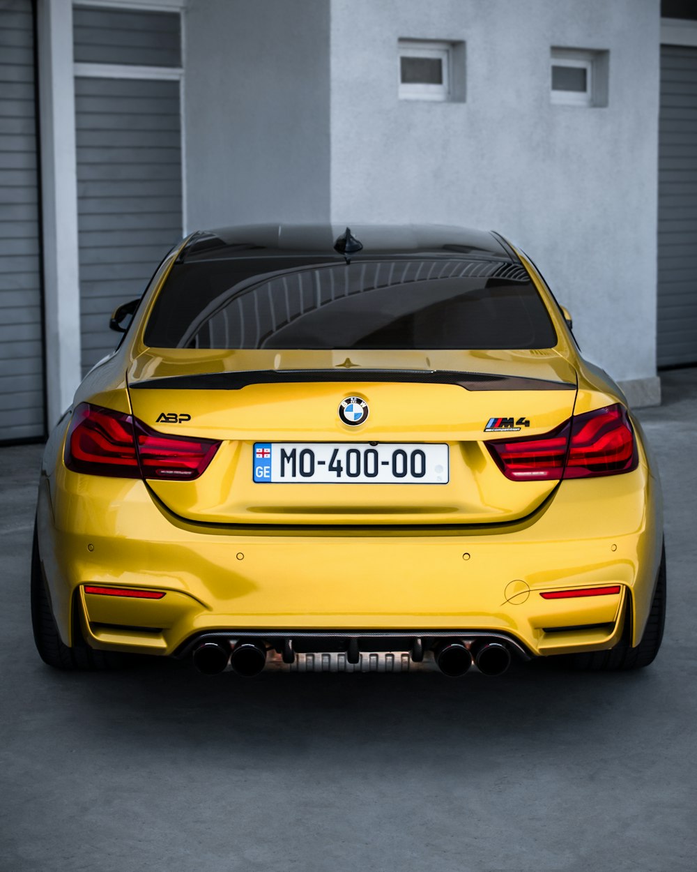 a yellow bmw car parked in a garage