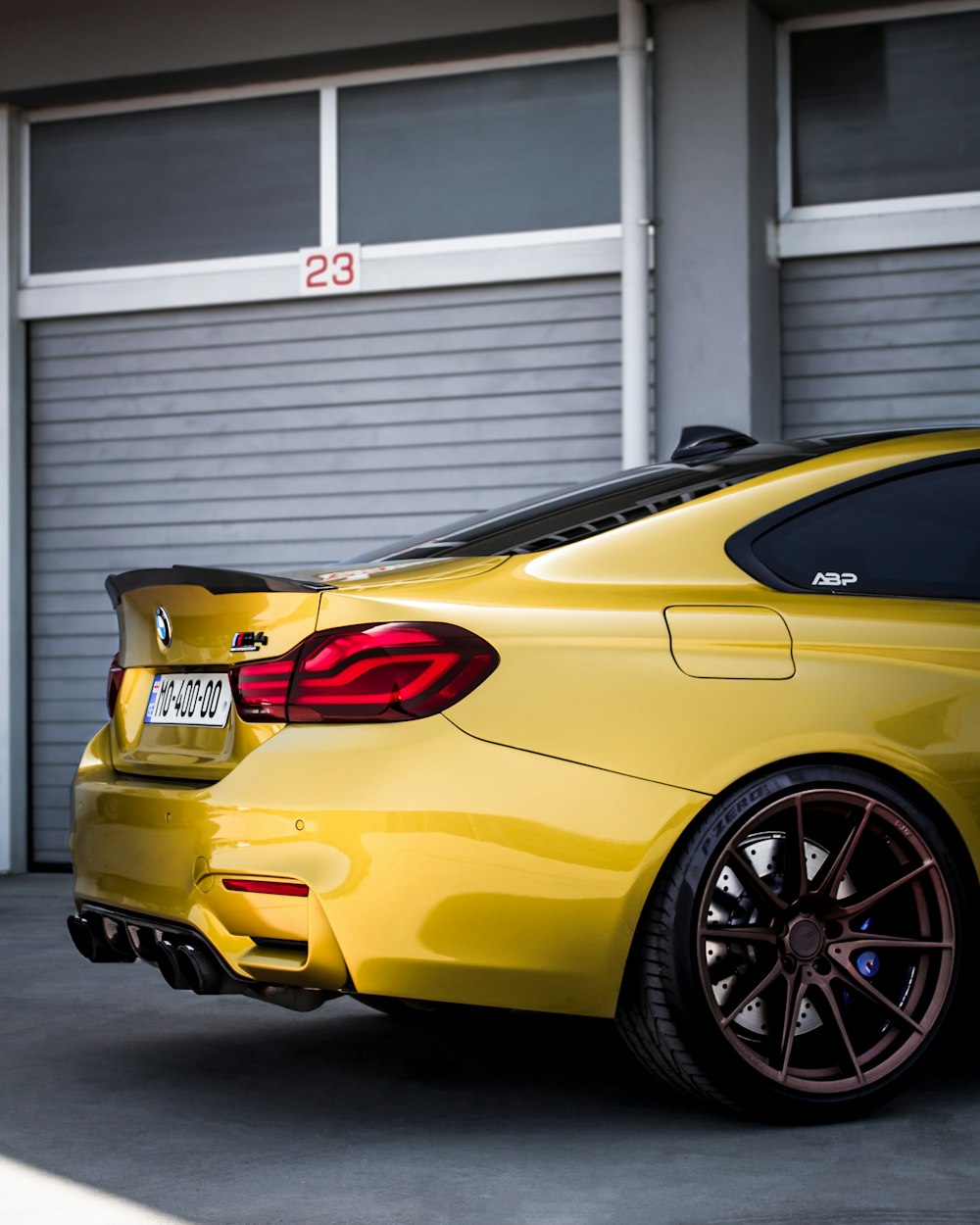 a yellow sports car parked in front of a garage