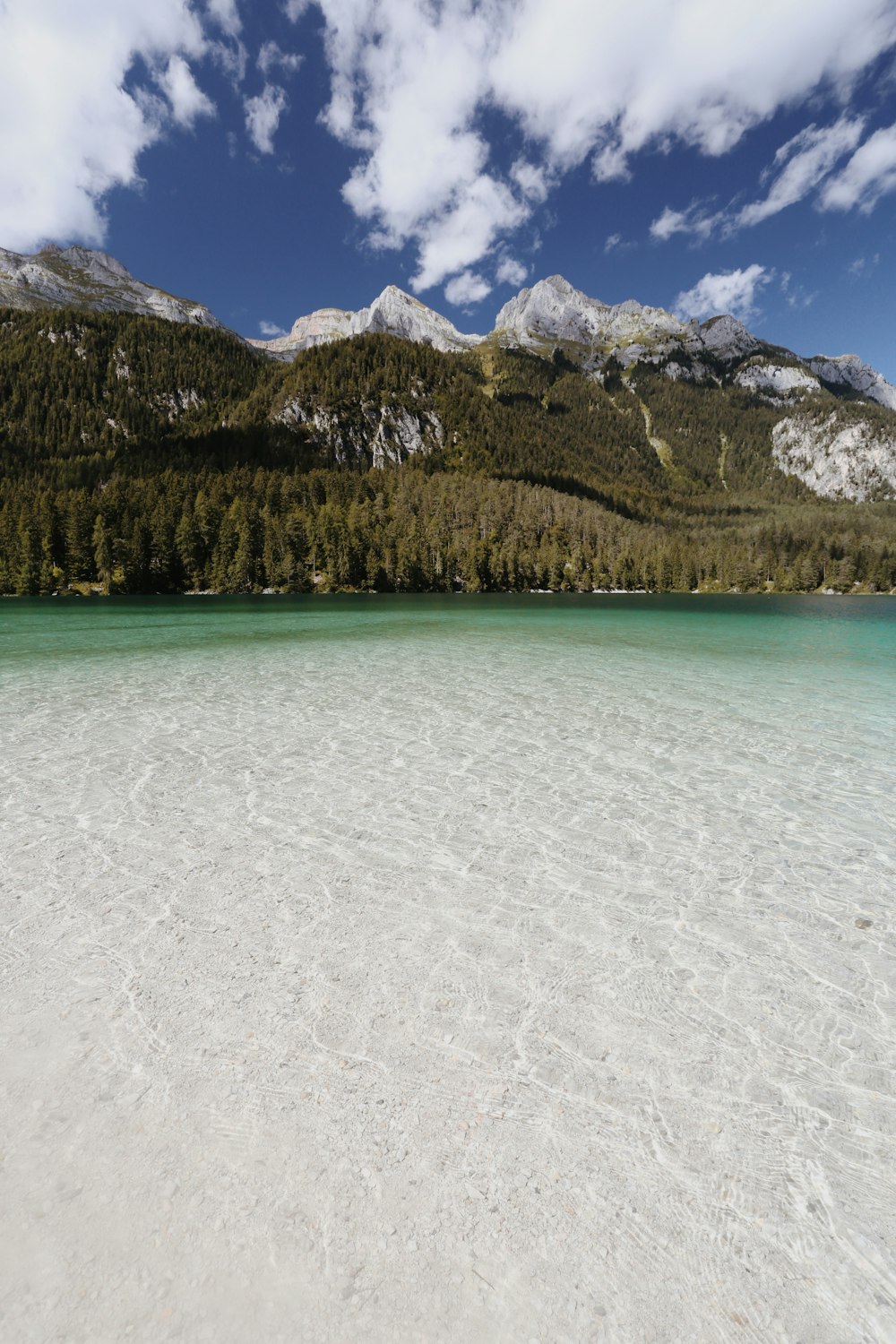 Ein von Bergen umgebener See unter blauem Himmel