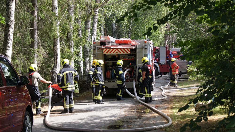 a group of firefighters standing next to a fire truck